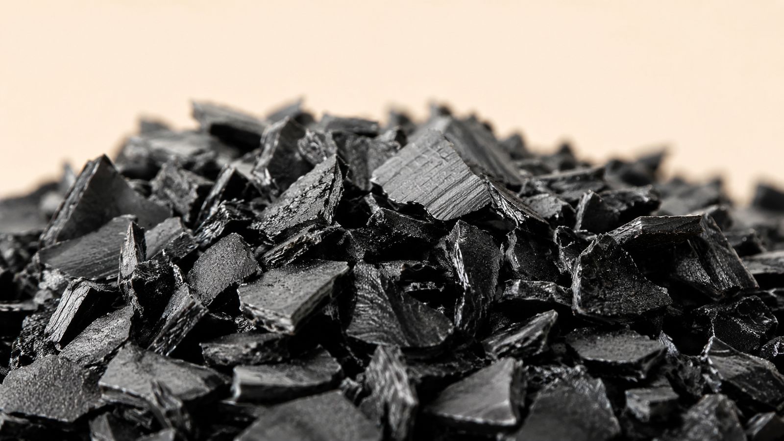 Czarne nieregularne płatki przemiału HDPE w studyjnym ujęciu makro